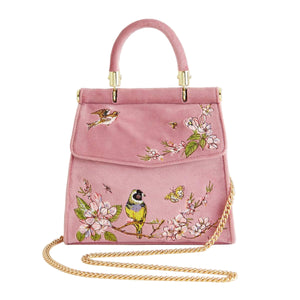 Pink handbag with floral and bird embroidery on a white background