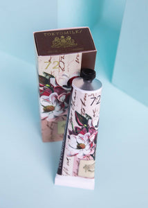 TOKYOMILK hand cream with floral design on a light blue background